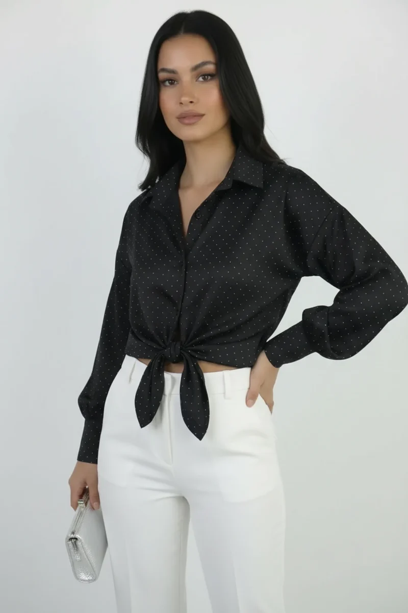 Czarna koszula damska z długimi rękawami, kołnierzykiem i wiązaniem w talii, wzór w kropki, styl casual, widok z przodu.