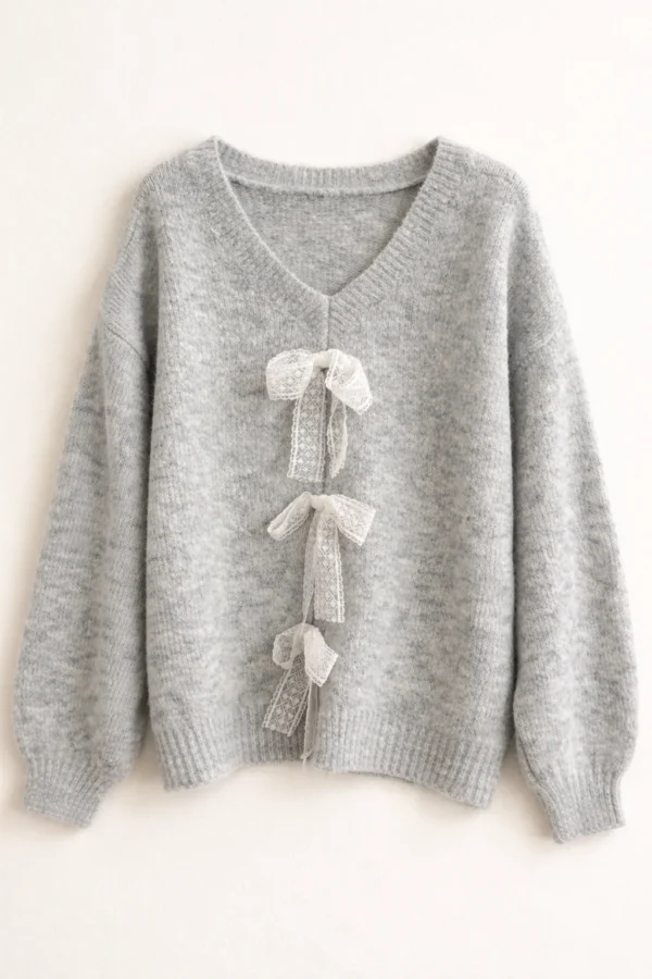 Szary damski sweter o luźnym kroju z dekoltem w serek i koronkowymi detalami z przodu, idealny na codzienne stylizacje.