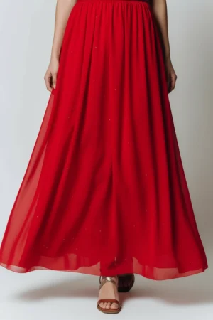 Długa, rozkloszowana czerwona sukienka z błyszczącymi elementami.