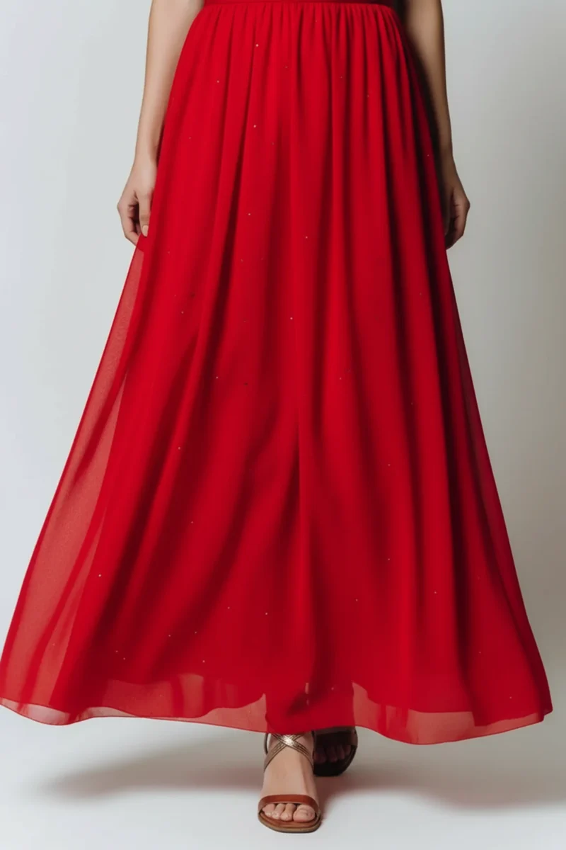 Długa, rozkloszowana czerwona sukienka z błyszczącymi elementami.