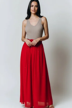 Młoda kobieta w czerwonej spódnicy maxi i beżowym topie